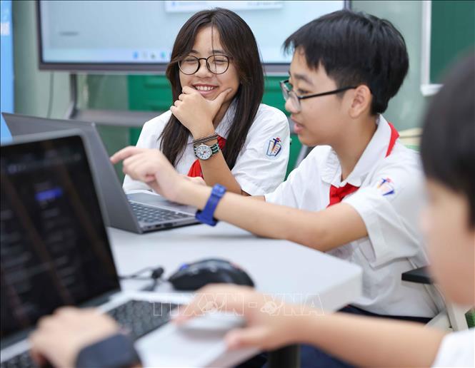 Học sinh Trường THCS Trưng Vương (phường Cửa Nam) chia sẻ, việc tiếp cận công nghệ thông tin tại trường khá thuận lợi nhờ sự hỗ trợ của thầy cô giáo. Em và các bạn được trực tiếp trải nghiệm các thiết bị, qua đó nhận thấy AI không chỉ hữu ích trong học tập mà còn trong cuộc sống hằng ngày. Ảnh: Thanh Tùng - TTXVN