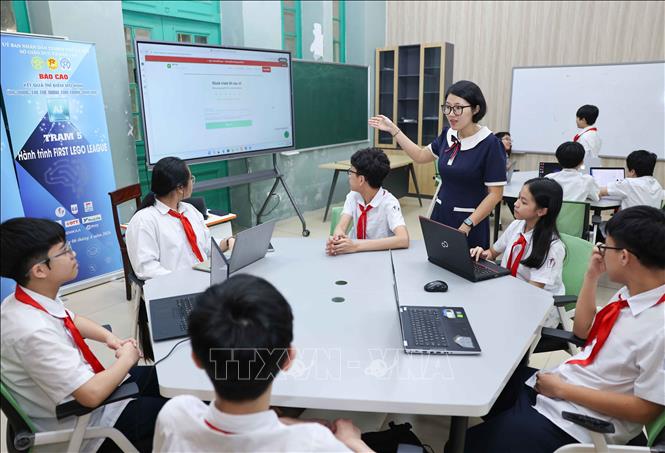 Trường THCS Trưng Vương (phường Cửa Nam) được giao nhiệm vụ tiên phong triển khai mô hình. Nhà trường tổ chức dạy học theo chuỗi hoạt động rõ ràng: Học sinh sử dụng công cụ số để tìm kiếm thông tin, kiểm chứng tư liệu, sáng tạo hình ảnh minh họa, trải nghiệm bài giảng qua bảo tàng thực tế ảo, đồng thời tham gia xây dựng tài nguyên học tập số. Ảnh: Thanh Tùng - TTXVN