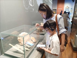 Du khách trải nghiệm ứng dụng thuyết minh tự động đa ngôn ngữ qua sóng Bluetooth tại Bảo tàng Đà Nẵng. Ảnh: Mỹ Hà - TTXVN