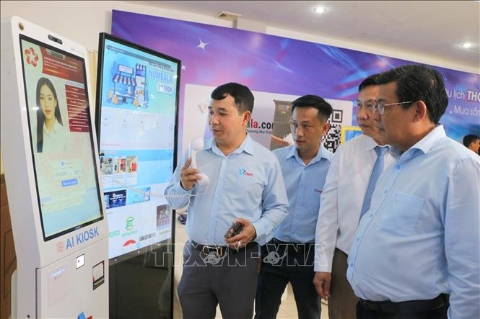 Phó Chủ tịch UBND tỉnh An Giang Ngô Công Thức (phải) cùng đoàn công tác kiểm tra các tính năng hỗ trợ của kios thông minh hỗ trợ người dân làm thủ tục hành chính. Ảnh: Công Mạo - TTXVN
