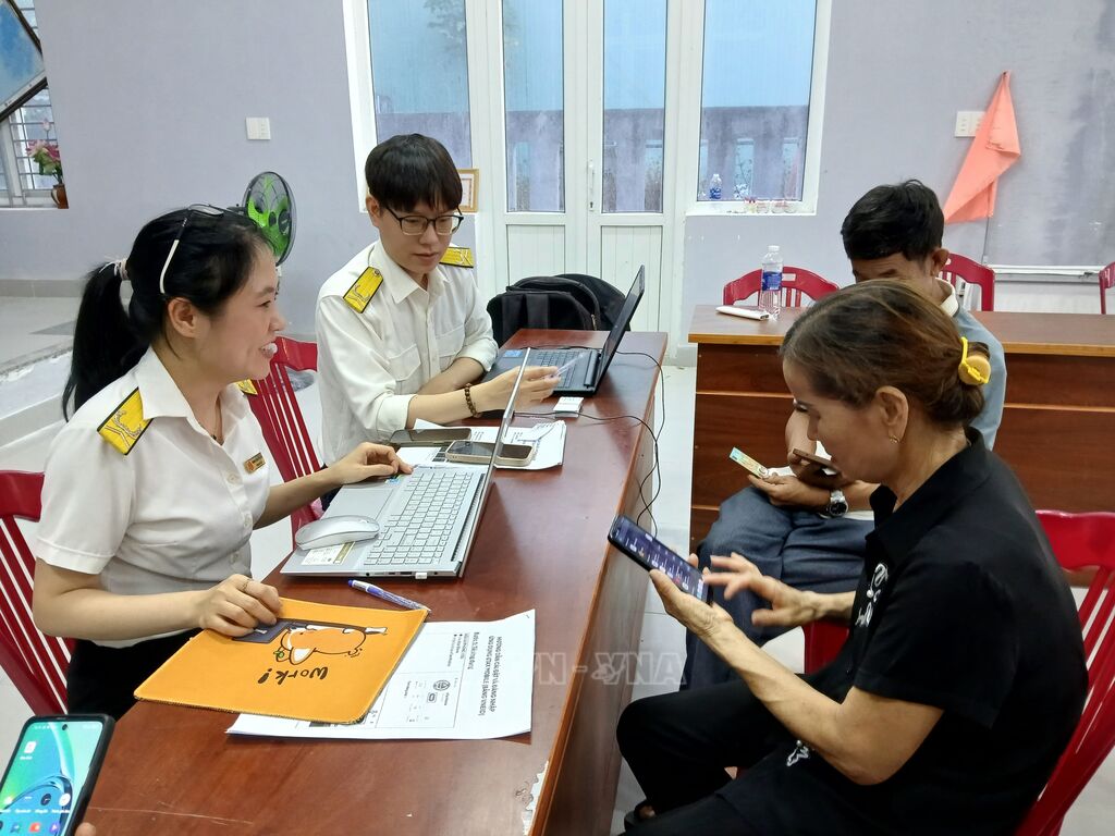 Tổ công nghệ số cộng đồng hỗ trợ người dân làm thủ tục hành chính. (Ảnh: Mỹ Hà/TTXVN) Tổ công nghệ số cộng đồng hỗ trợ người dân làm thủ tục hành chính. (Ảnh: Mỹ Hà/TTXVN)