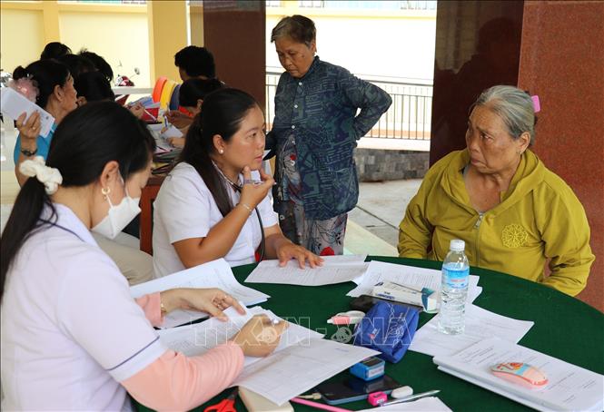Nhân viên y tế Trạm Y tế xã An Thạnh Thủy, tỉnh Đồng Tháp tư vấn người cao tuổi cập nhật Sổ sức khỏe điện tử trên ứng dụng VneID. (Ảnh: Hữu Chí/TTXVN)