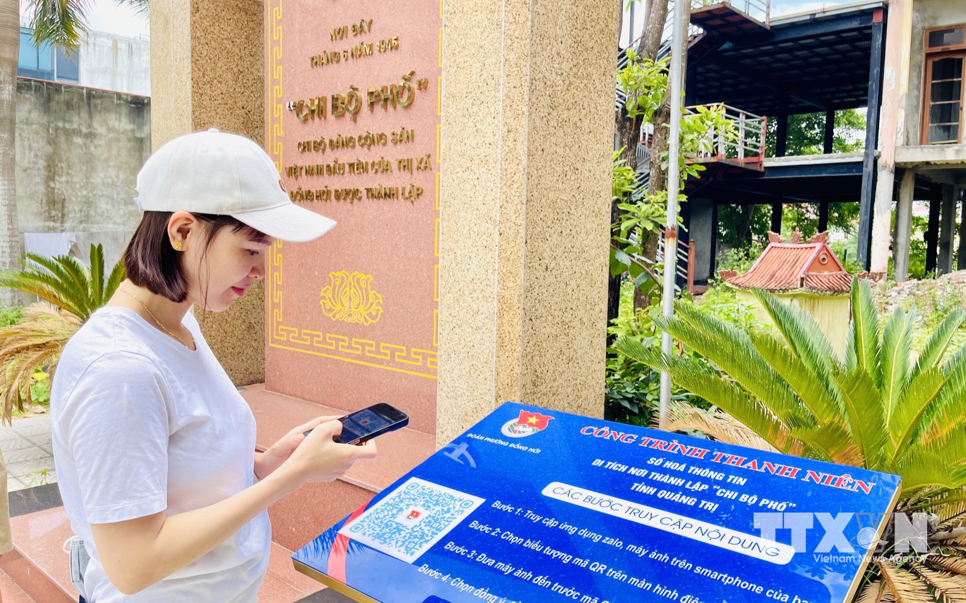 Du khách đến từ tỉnh Đắk Lắk trải nghiệm quét mã QR tại di tích nơi thành lập “Chi bộ phố” tỉnh Quảng Trị (Chi bộ Đảng Cộng sản Việt Nam đầu tiên của thị xã Đồng Hới được thành lập). (Ảnh: Võ Dung/TTXVN)