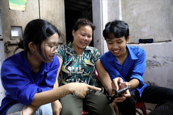 Đoàn Thanh niên xã Vũ Tiên (tỉnh Hưng Yên) hướng dẫn người dân cách sử dụng điện thoại thông minh để thực hiện các dịch vụ công trực tuyến và nhận diện các chiêu trò lừa đảo trên không gian mạng. (Ảnh: Thế Duyệt/TTXVN)