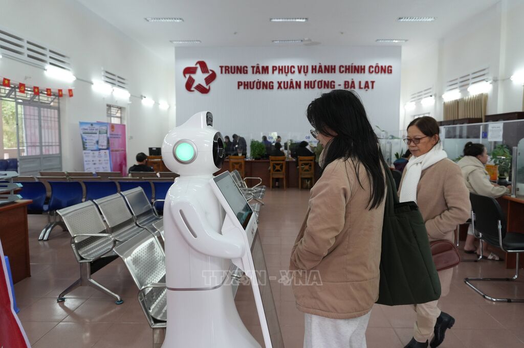 Hai mẹ con bà Trần Thị Bích Hiền (phường Xuân Hương – Đà Lạt) nhờ robot AI hướng dẫn thủ tục cấp lại giấy chứng nhận đăng ký kinh doanh chiều 10/8. (Ảnh: Nguyễn Dũng/ TTXVN) Hai mẹ con bà Trần Thị Bích Hiền (phường Xuân Hương – Đà Lạt) nhờ robot AI hướng dẫn thủ tục cấp lại giấy chứng nhận đăng ký kinh doanh chiều 10/8. (Ảnh: Nguyễn Dũng/ TTXVN)