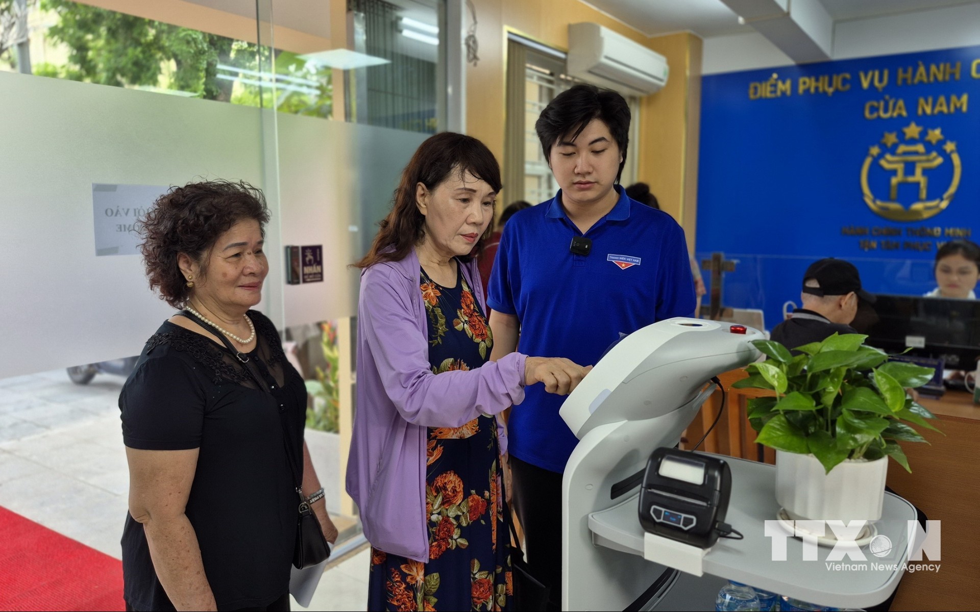 Người dân trải nghiệm Robot AI áp dụng công nghệ trí tuệ nhân tạo hỗ trợ thực hiện các thủ tục hành chính tại phường Cửa Nam,Hà Nội. (Ảnh: Nguyễn Thắng/TTXVN)