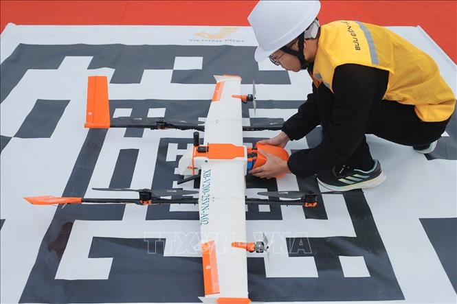 Nhân viên kỹ thuật của VNPost chuẩn bị vận hành thiết bị UAV trong việc vận chuyển mẫu bệnh phẩm y tế. (Ảnh: Minh Quyết/TTXVN)