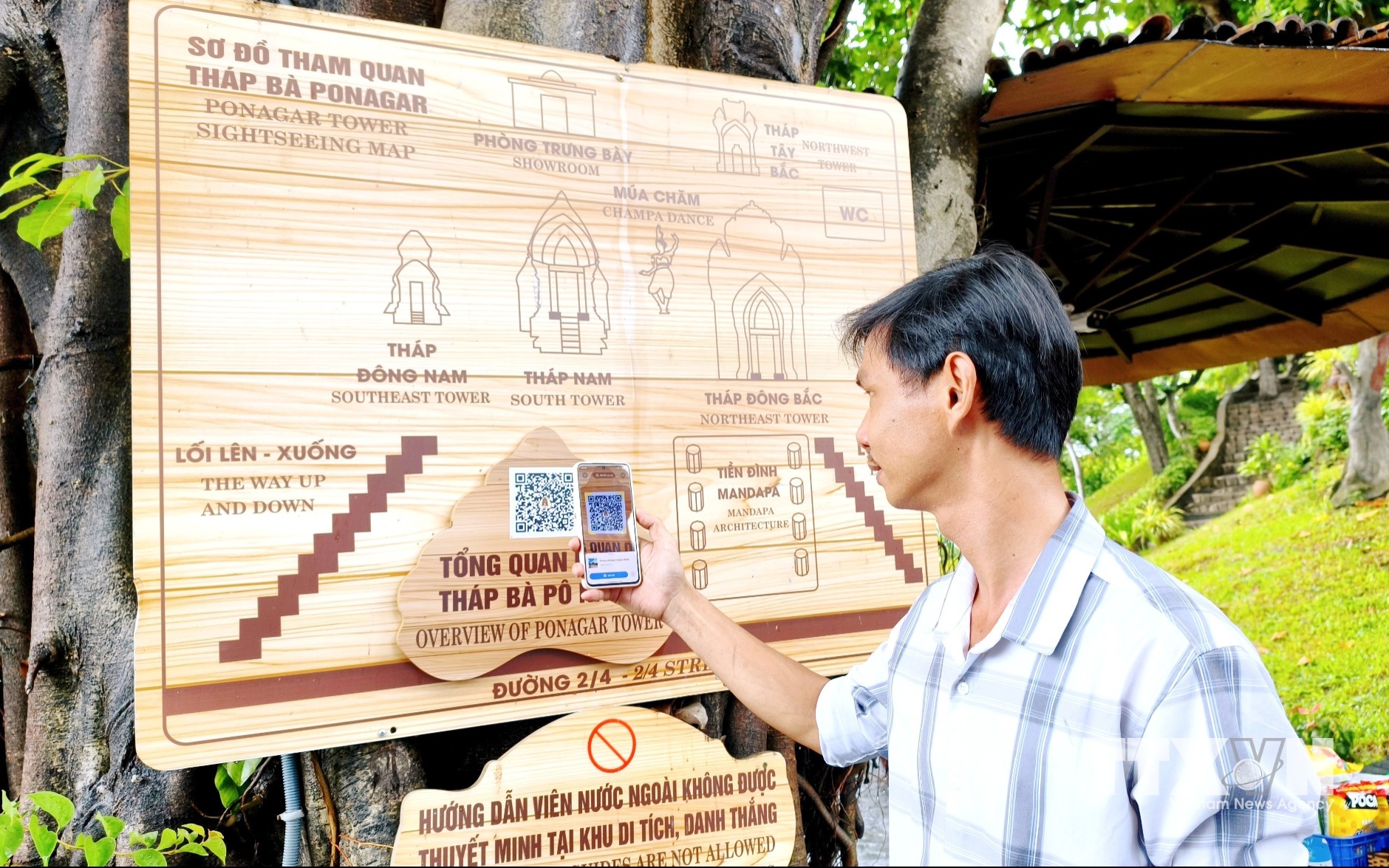 Du khách quét mã QRcode tìm hiểu thông tin tại Di tích quốc gia đặc biệt Tháp Bà Pô Nagar (phường Bắc Nha Trang). (Ảnh: Nguyễn Thành/TTXVN)