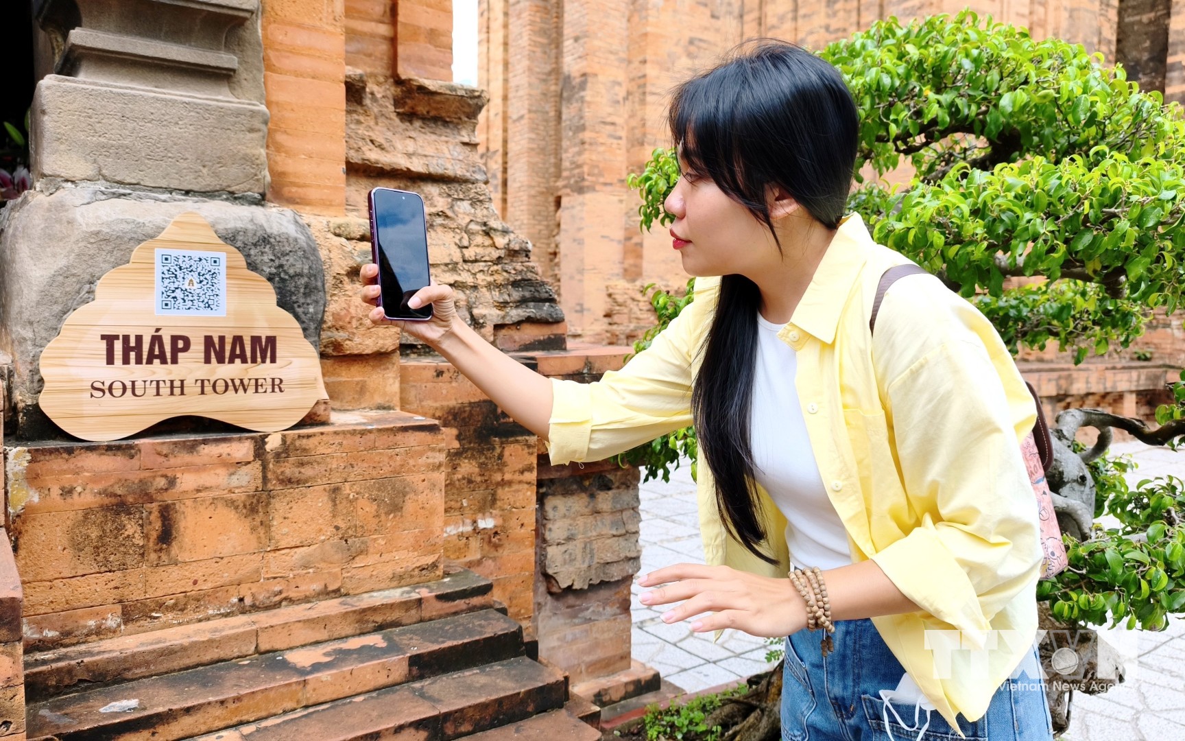 Du khách quét QR tìm hiểu thông tin tại Di tích quốc gia đặc biệt Tháp Bà Pô Nagar (phường Bắc Nha Trang). (Ảnh: Nguyễn Thành/TTXVN)