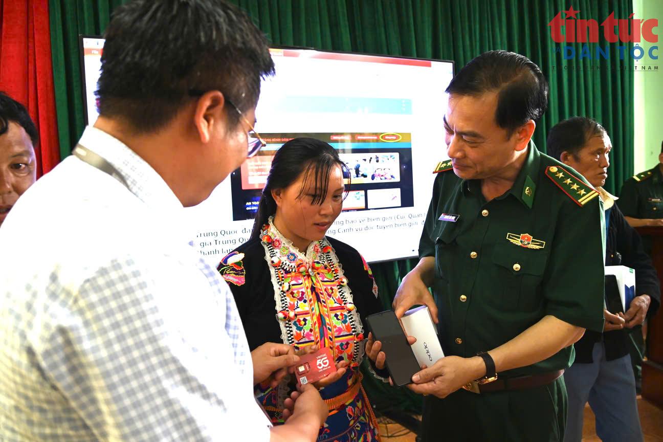 Đại tá Nguyễn Văn Hưng tặng máy điện thoại thông minh cho đồng bào biên giới tham gia bán hàng trên sàn thương mại điện tử. Ảnh: Viết Tôn/Báo Tin tức và Dân tộc