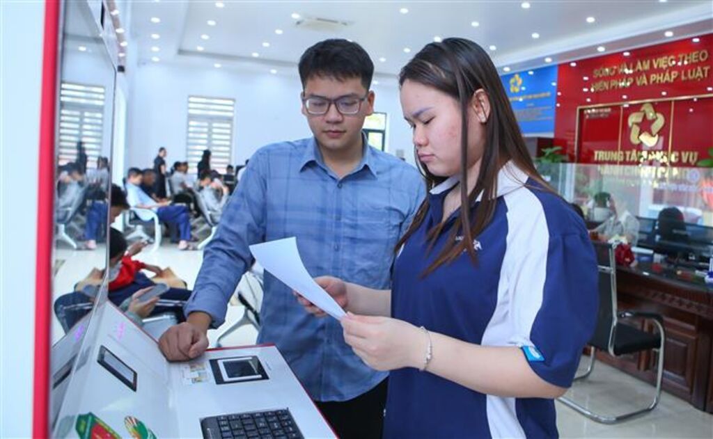 Kiểm tra lại kết quả sau khi thực các thủ tục tại Kiosk hành chính công thông minh xã Rạng Đông. (Ảnh: Công Luật /TTXVN)