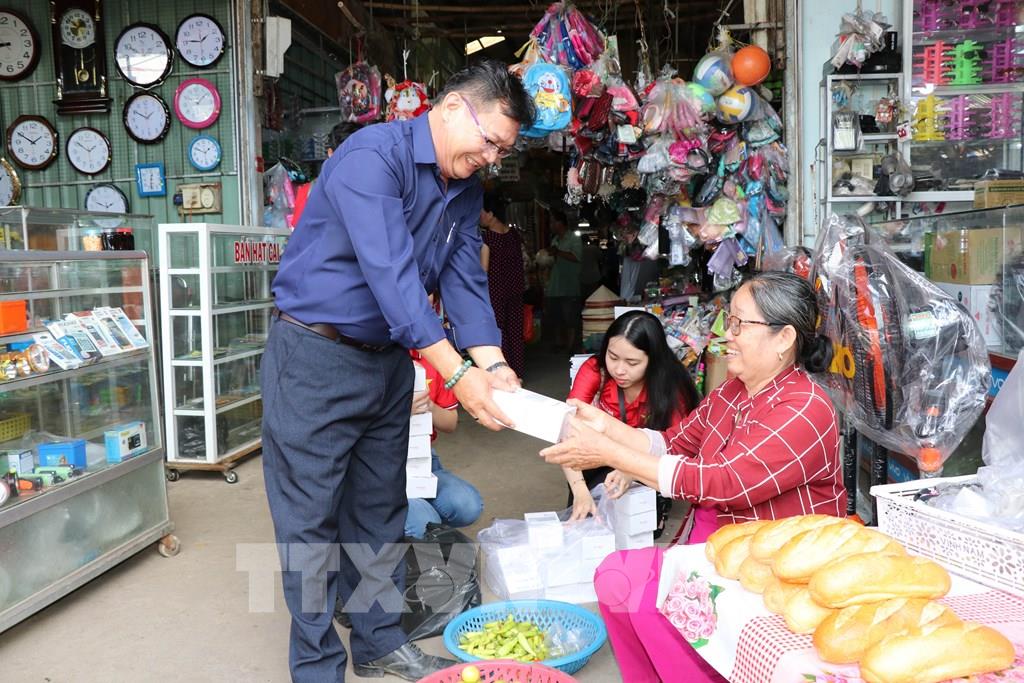 Trao thiết bị hỗ trợ tiểu thương chợ Nhị Long dùng phương thức thanh toán không dùng tiền mặt. (Ảnh: Thanh Hòa- TTXVN)
