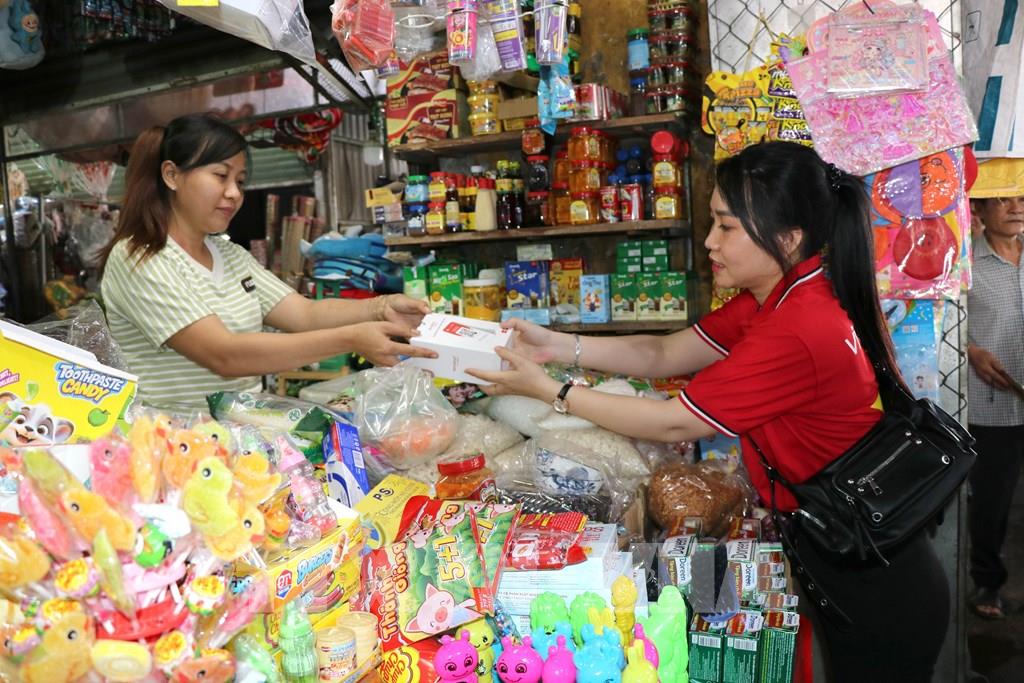 Trao thiết bị hỗ trợ tiểu thương chợ Nhị Long dùng phương thức thanh toán không dùng tiền mặt. (Ảnh: Thanh Hòa- TTXVN)