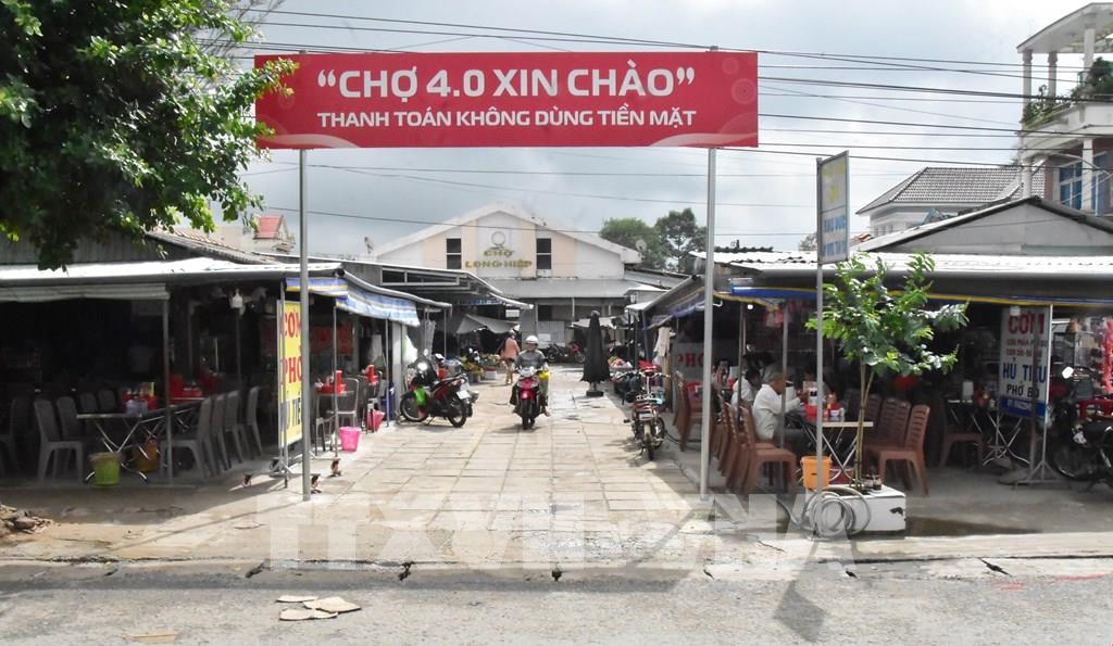 Chợ Long Hiệp triển khai mô hình “Chợ 4.0”, khuyến khích tiểu thương và người dân thanh toán không dùng tiền mặt. (Ảnh: Thanh Hòa - TTXVN)