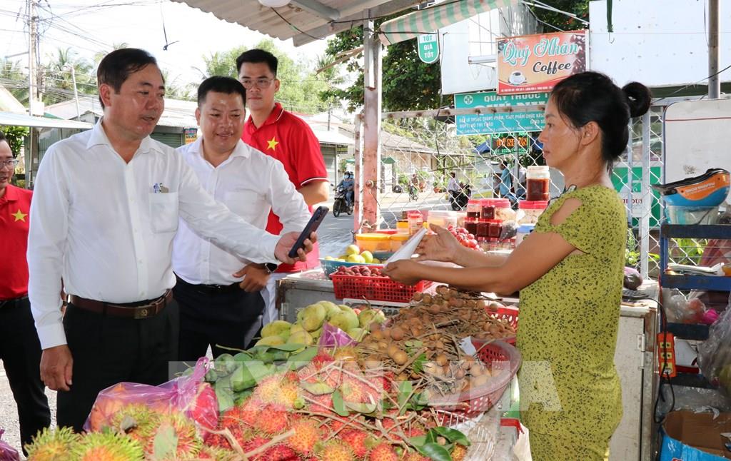 Lãnh đạo UBND xã Song Lộc tuyên truyền, hướng dẫn tiểu thương sử dụng phương thức thanh toán không dùng tiền mặt.( Ảnh: Thanh Hòa - TTXVN) Lãnh đạo UBND xã Song Lộc tuyên truyền, hướng dẫn tiểu thương sử dụng phương thức thanh toán không dùng tiền mặt.( Ảnh: Thanh Hòa - TTXVN)