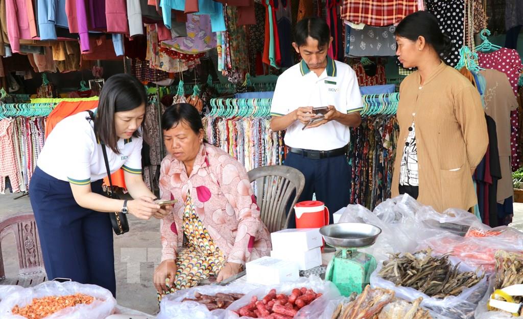 Hỗ trợ tiểu thương chợ Cầu Xây tại tài khoản ngân hàng và hướng dẫn sử dụng. (Ảnh: Thanh Hòa - TTXVN) Hỗ trợ tiểu thương chợ Cầu Xây tại tài khoản ngân hàng và hướng dẫn sử dụng. (Ảnh: Thanh Hòa - TTXVN)