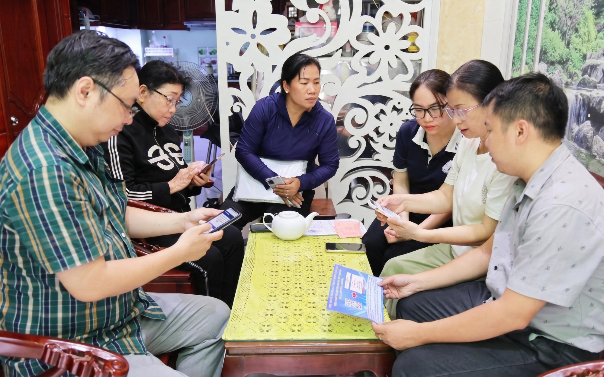 Cán bộ khu phố hướng dẫn người cao tuổi sử dụng dịch vụ công trực tuyến tại nhà.&nbsp;(Ảnh: Lưu Niệm/Báo Tin tức và Dân tộc)
