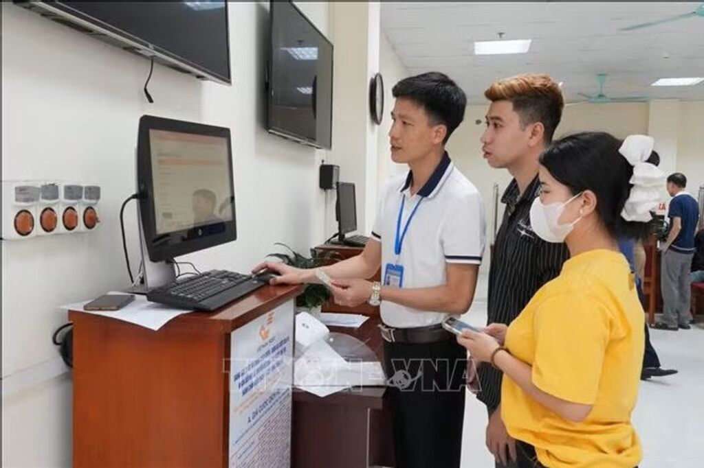 Cán bộ Trung tâm Phục vụ hành chính công phường Vĩnh Yên hướng dẫn người dân làm thủ tục đăng kí kết hôn trên cổng dịch vụ công trực tuyến. (Ảnh: Nguyễn Thảo/TTXVN)