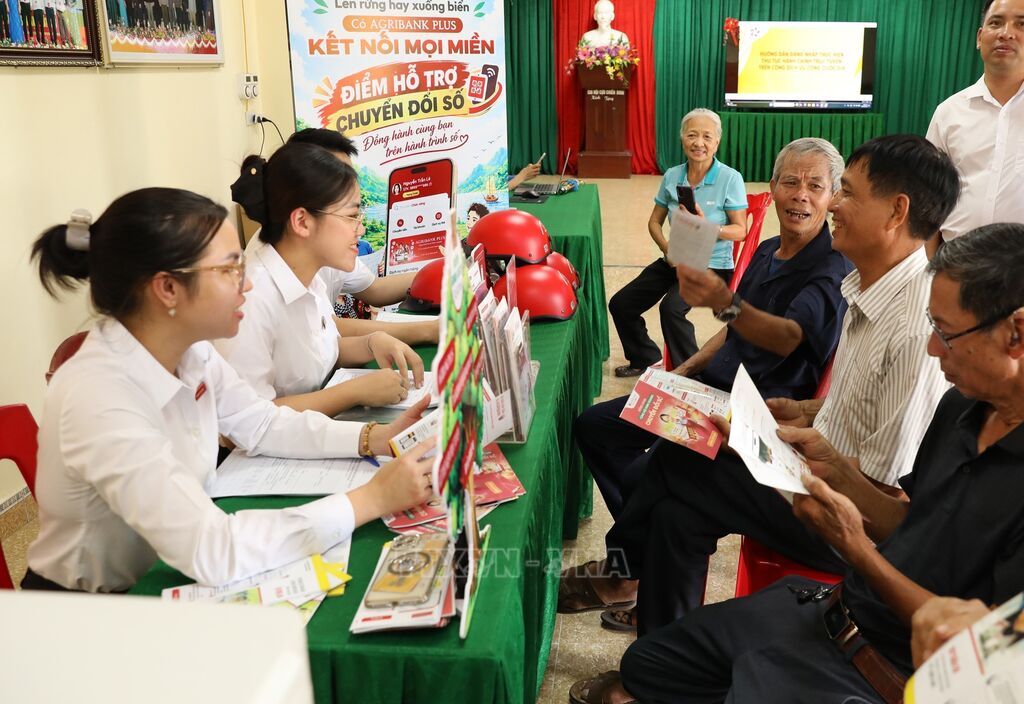Người dân được giải đáp nhiều thắc mắc liên quan đến sử dụng tài khoản ngân hàng tại Điểm chuyển đổi số số (Ảnh: Đức Phương/TTXVN)