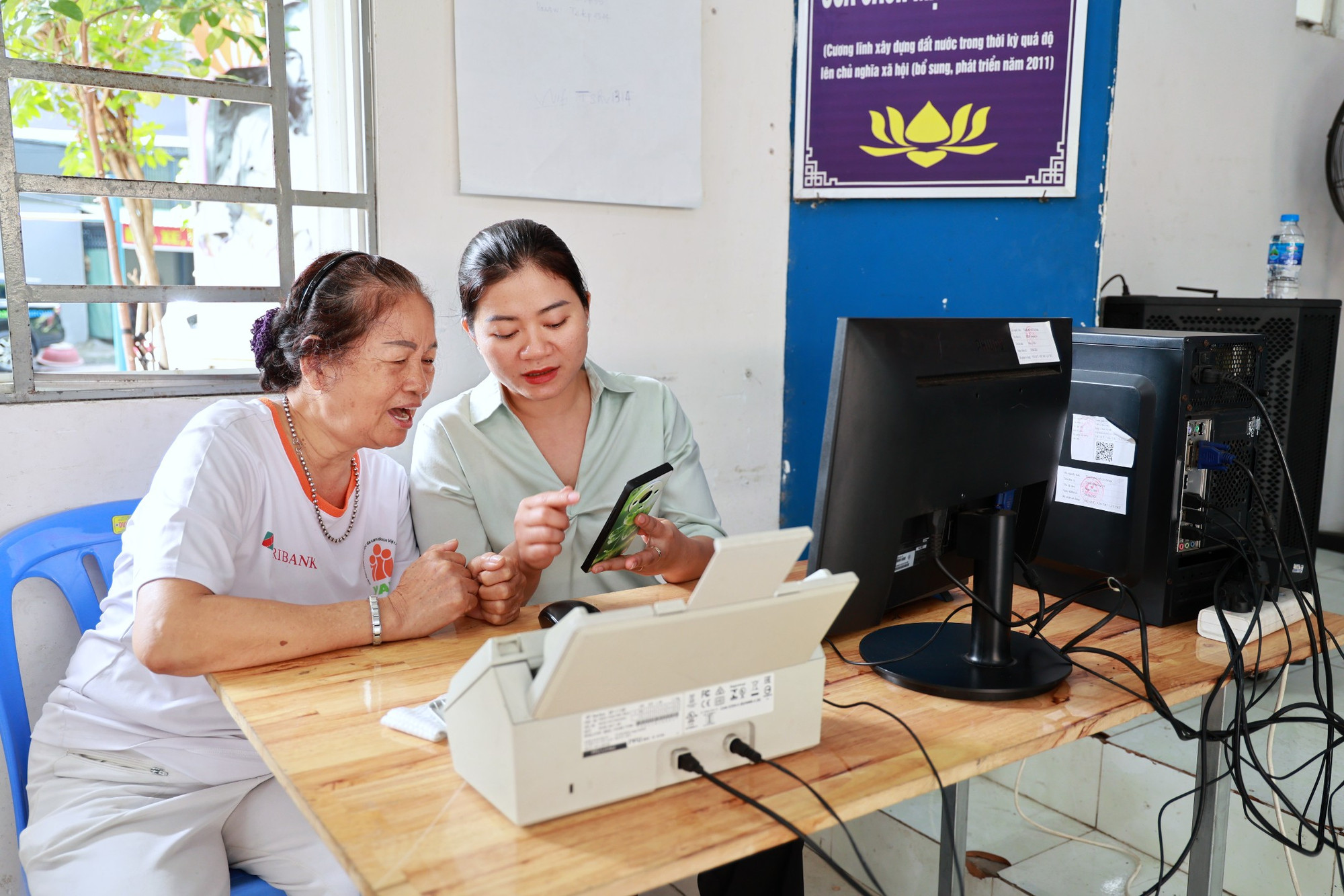 Cán bộ phường Tân Bình (TP Hồ Chí Minh) hướng dẫn người dân thực hiện thủ tục hành chính trên môi trường số tại “Điểm hỗ trợ dịch vụ công trực tuyến cho người dân”. (Ảnh: Lưu Niệm/Báo Tin tức và Dân tộc)