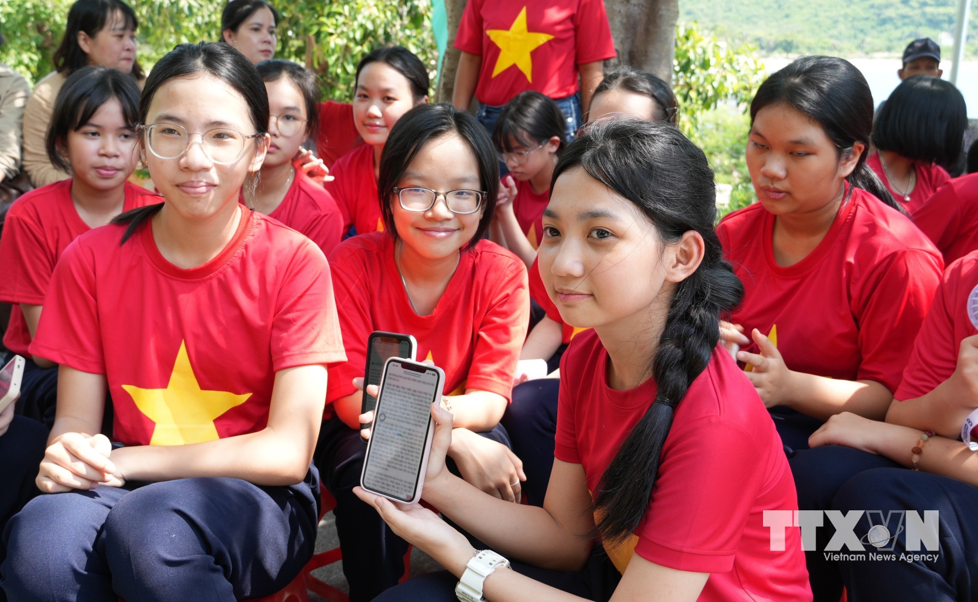 Học sinh sử dụng điện thoại di động quét mã QR tại Khu Di tích lịch sử cấp quốc gia Tàu không số 235. (Ảnh: Phan Sáu/TTXVN)