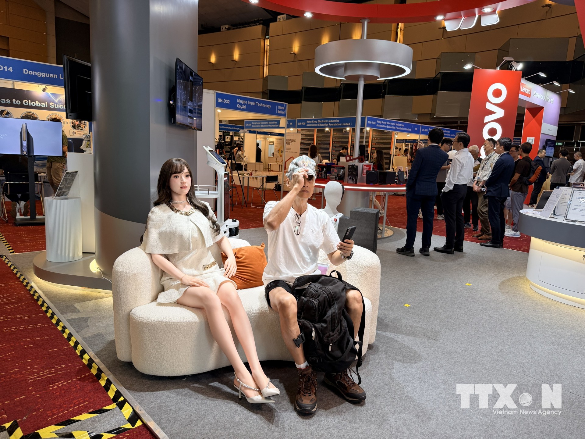 Khách tham quan triển lãm thử nghiệm giao lưu với robot. (Ảnh: Lê Anh/TTXVN)