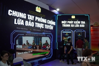 Người dân tham quan triển lãm “Bức tường An ninh mạng”được trực tiếp nhận diện những thủ đoạn lừa đảo trực tuyến phổ biến trên không gian mạng. (Ảnh: Hùng Mạnh/TTXVN)