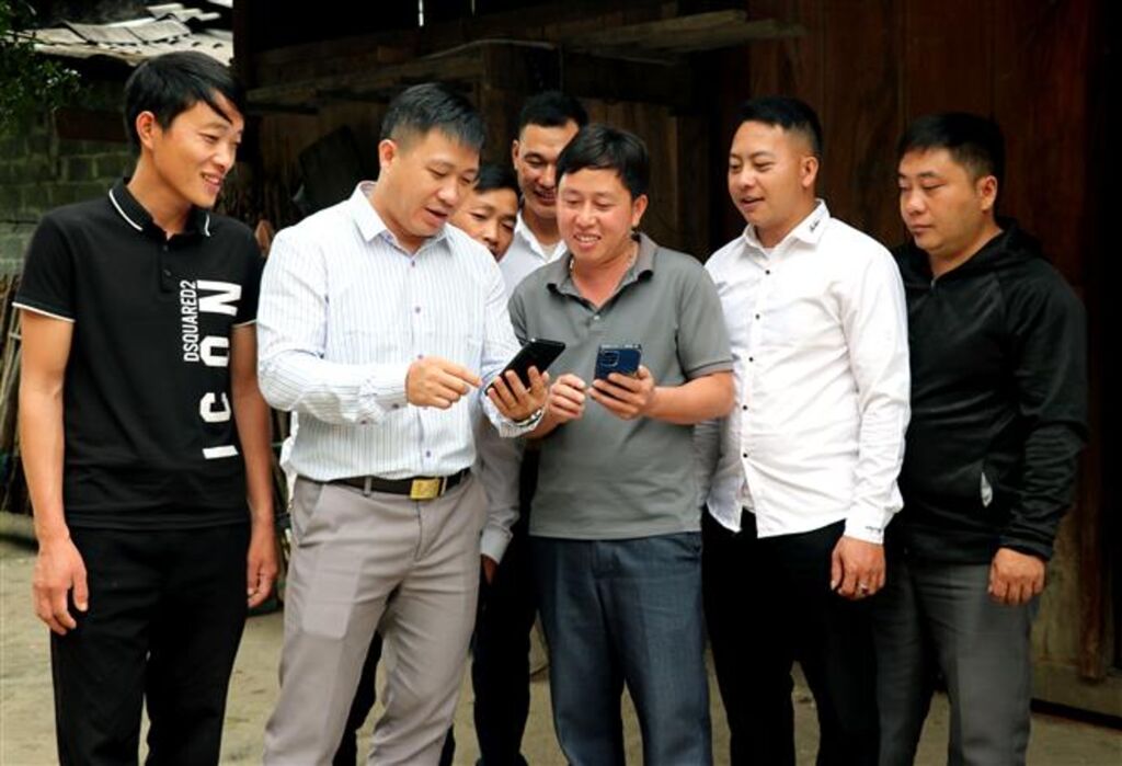 Cán bộ tổ công tác xã Đường Thượng “cầm tay chỉ việc”, hướng dẫn tỉ mỉ từng đảng viên sử dụng Sổ tay đảng viên điện tử và thực hiện nộp đảng phí qua Cổng Dịch vụ công quốc gia. (Ảnh: Đức Thọ/TTXVN)